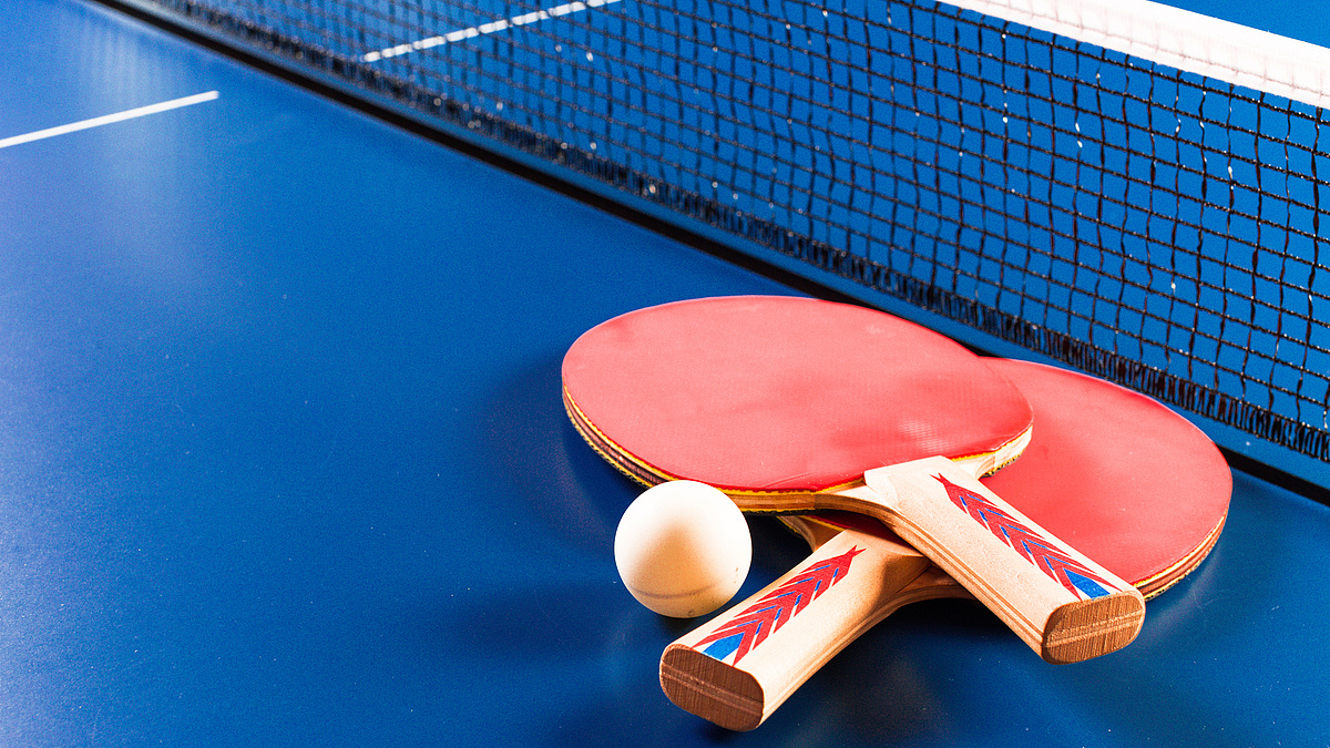 Tischtenniskellen und -ball auf Platte