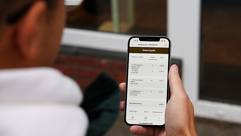 Smartphone mit Bon auf Display, bargeldoses Zahlen